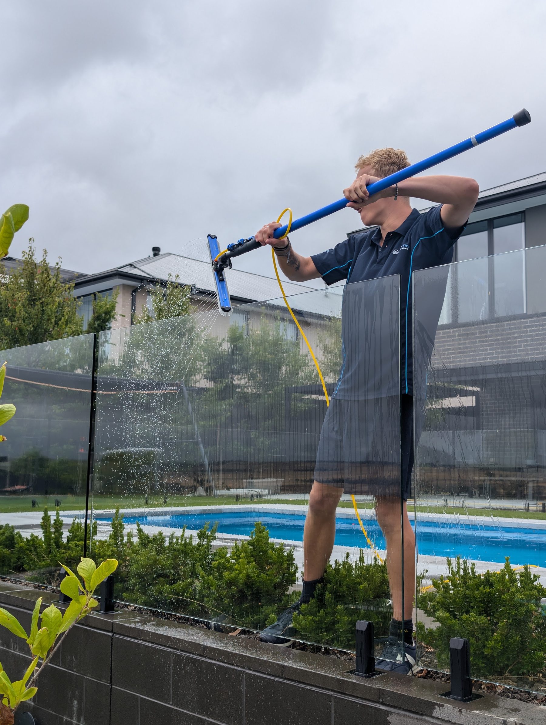 pool glass — modern home — Tiled pool deck soft-washed and rinsed on a Surf Coast property — paver-safe, kid-safe runoff.